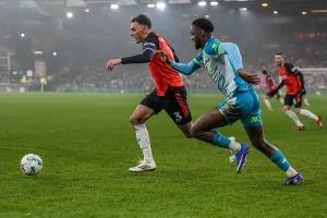 Luton guarantees a meeting at Wembley after victory over Northampton.