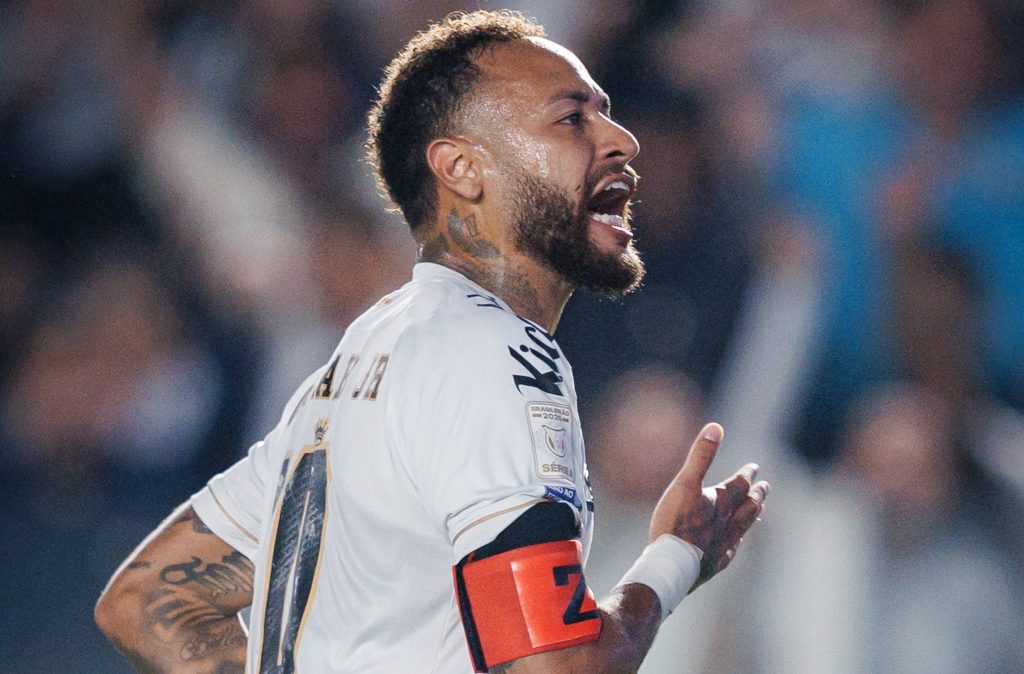 Jogador do Santos, de camisola branca n.º 11 e braçadeira de capitão, grita a celebrar um golo em campo.