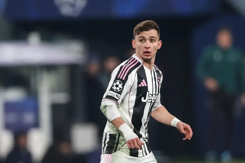 Jogador da Juventus, de listas pretas e brancas e patrocínio Jeep, olha para o lado durante um jogo da Liga dos Campeões.