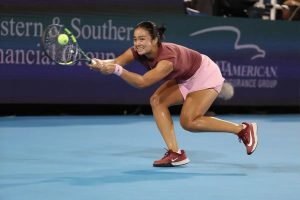 Tennis player in a maroon top and pink skirt lunges to hit a forehand on a blue court at a Western & Southern Open match; the article names Alex Eala.