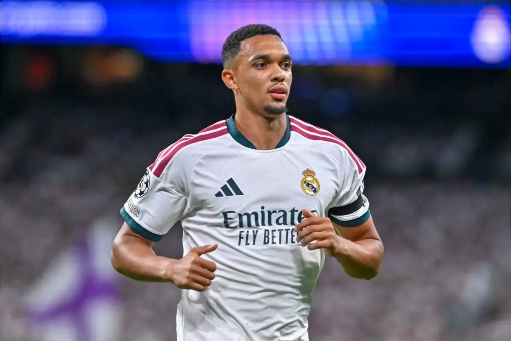 Trent Alexander-Arnold in a white Real Madrid kit with captain's armband, jogging during a match at the Bernabéu stadium