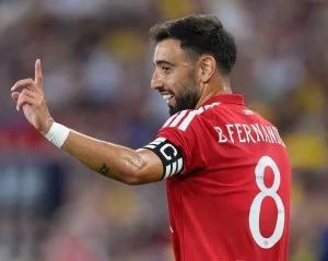 Jogador com camisola vermelha do Manchester United, número 8 e braçadeira de capitão, a gesticular para a frente num jogo