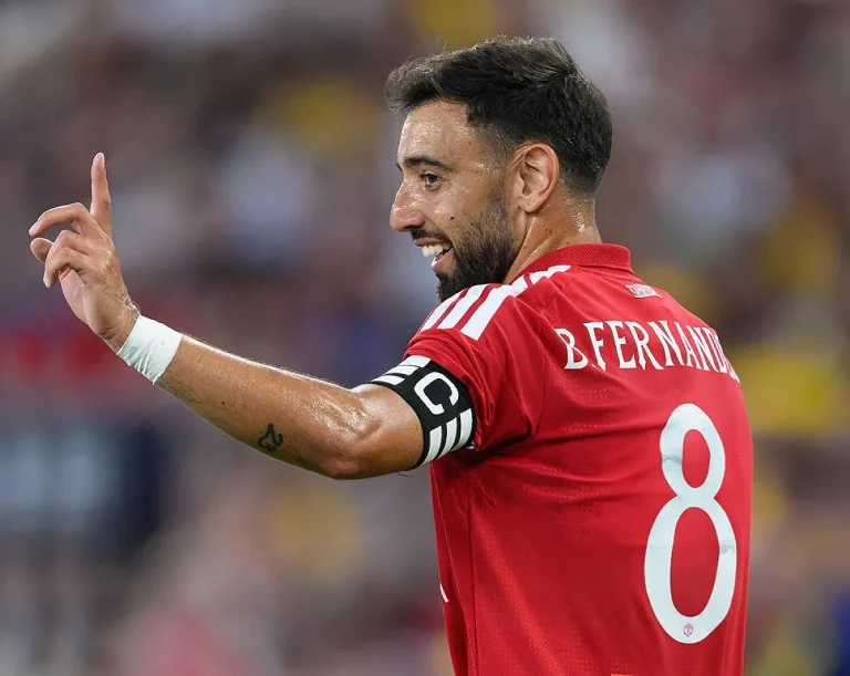 Jogador com camisola vermelha do Manchester United, número 8 e braçadeira de capitão, a gesticular para a frente num jogo