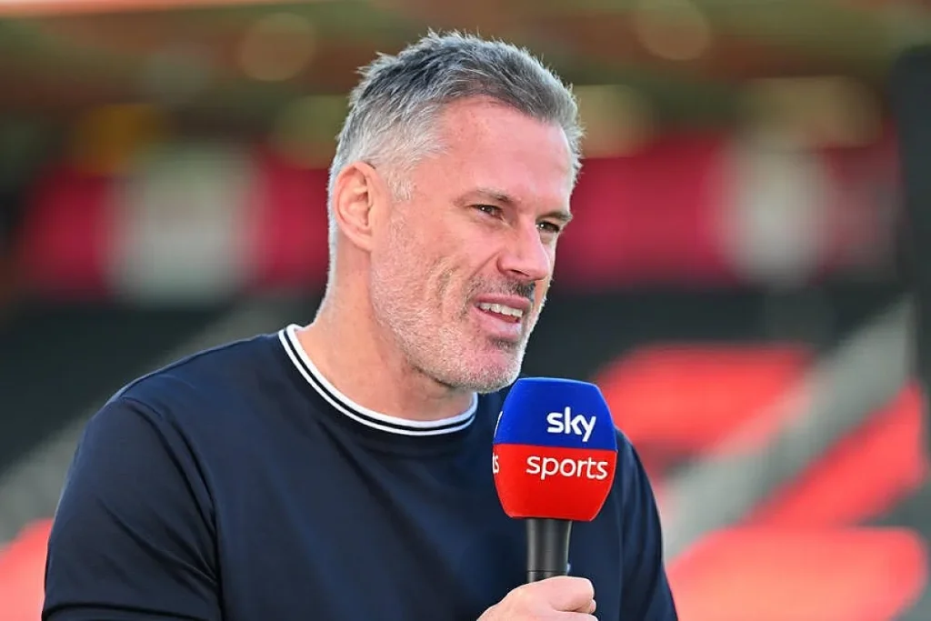 Homem de cabelo grisado e barba curta, camisola azul-marinho, a falar ao microfone da Sky Sports num estádio com bancadas vermelhas.