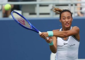 A tennis player in a white Nike top with vivo sponsor logo swings a blue Wilson racket during a match at the Billie Jean King Cup