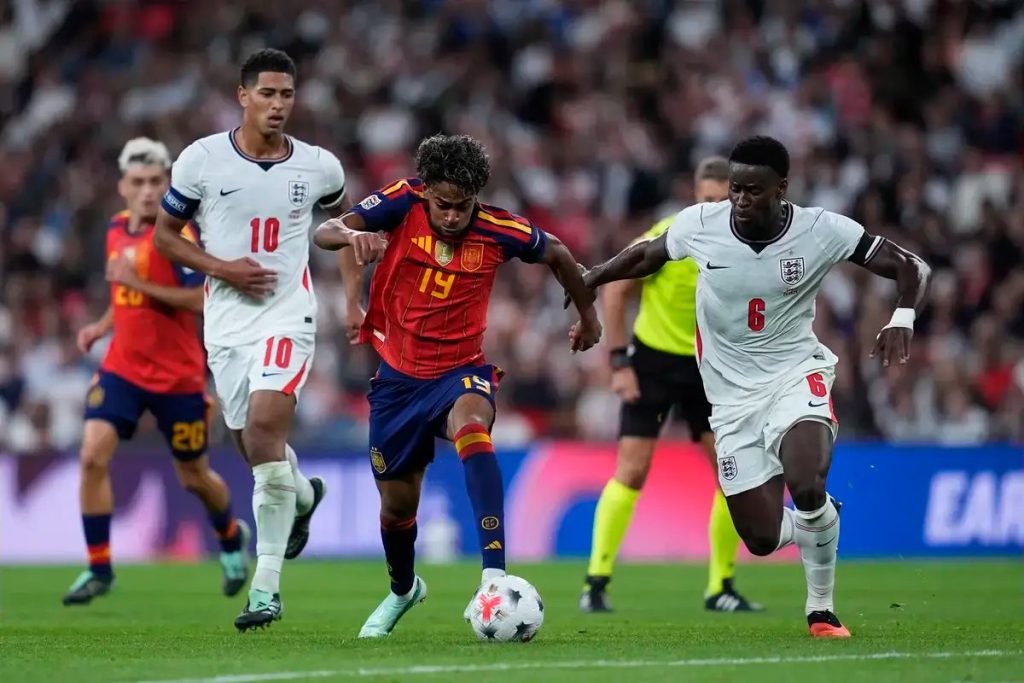 Spain's No. 19 in red battles England's Nos. 10 and 6 in white for the ball during a match at Wembley