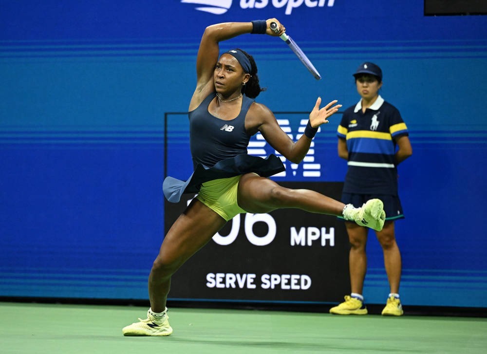 Tennis player in navy and lime outfit mid-swing on a serve at the US Open, with a "106 MPH serve speed" graphic behind her
