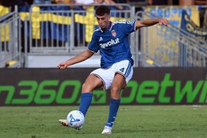 Jacobo Ramon in blue Celta Vigo-style kit with number 4 strikes the ball during a match, grass pitch and stadium behind him