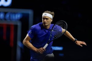 Alexander Zverev in a blue shirt and white headband mid-stride with his racket during a match at the Laver Cup