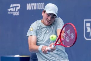 Tennis player in light grey cap and shirt hitting a forehand with a red Yonex racquet at an ATP Masters 1000 event.