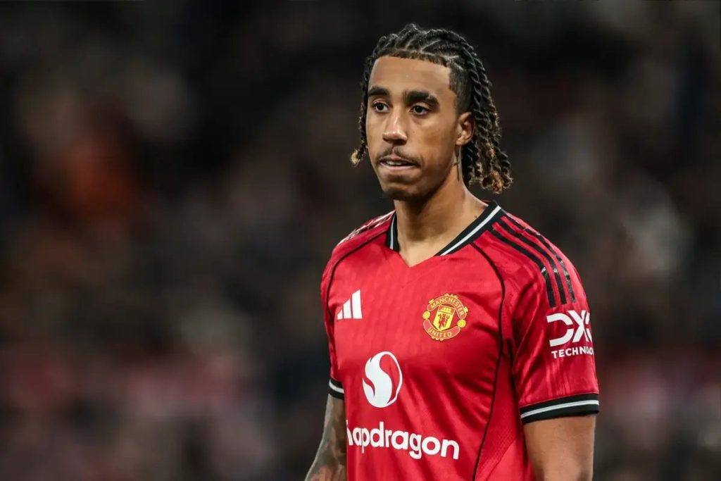 Footballer in red Manchester United home kit with Adidas and Snapdragon sponsors, braided hair, looking to the side during a match